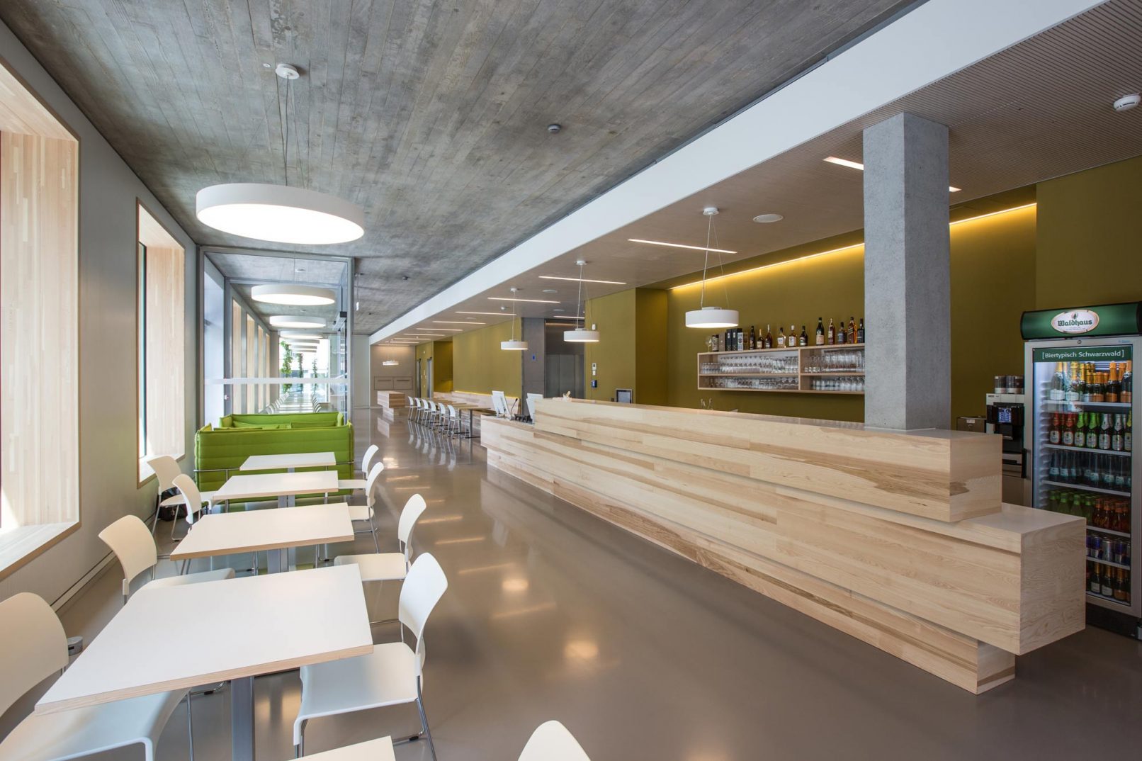 Innenausbau des Frühstücksraums eines Hotels in Freiburg mit Theke und Sitzgruppen