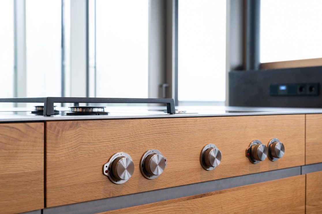 Bedienelemente eines Kochfelds mit Holzfront