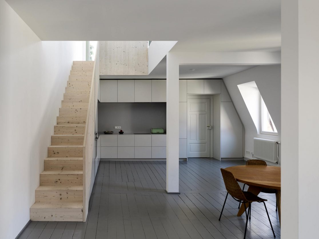 Küche und Essgruppe in weißer Farbe neben Treppenaufgang