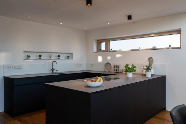 schwarzes Küchenelement mit grauer Oberfläche unterhalb Fenster in Freiburg