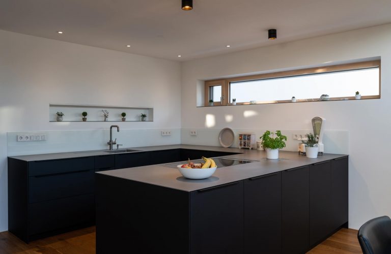 schwarzes Küchenelement mit grauer Oberfläche unterhalb Fenster in Freiburg